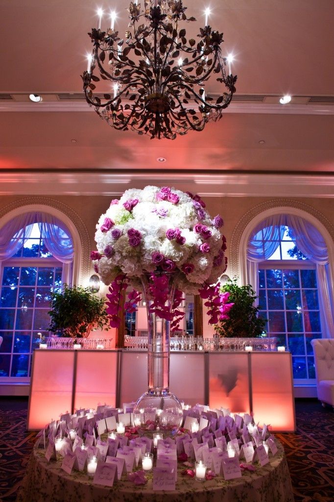 Opulent arrangement floats on a glass pedestal above the card table.