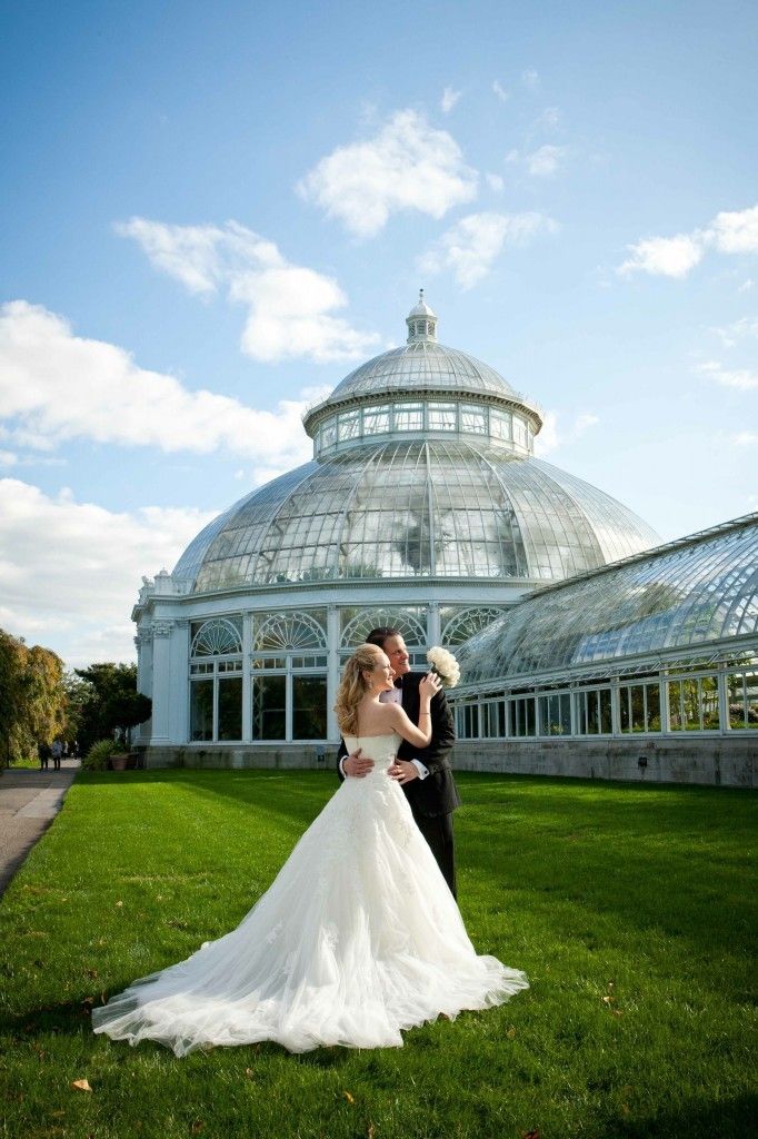 Newlyweds in front of Victorian glasshouse.