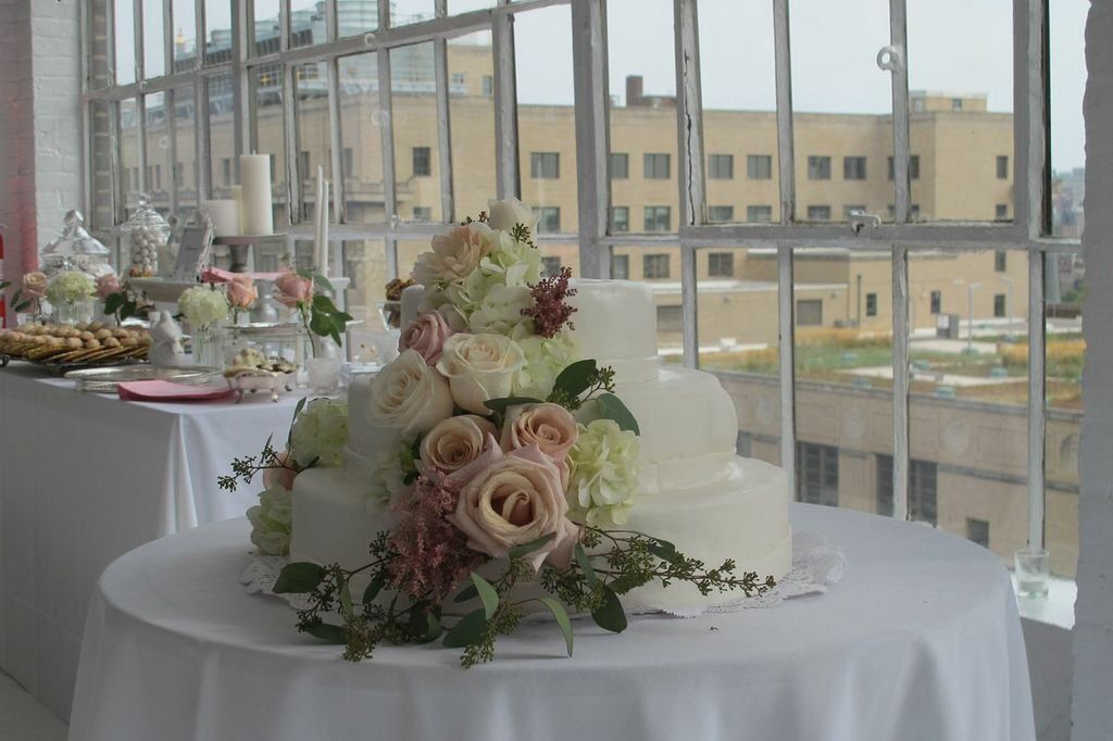 Romantic cake with roses, wild flowers, dahlias and hydrangeas.