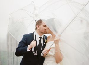 Tracy and Ben Wedding - Bride and Groom Kiss Under Umbrella - Le Parker Meridien NYC - Kathleen and Robert Photographers -